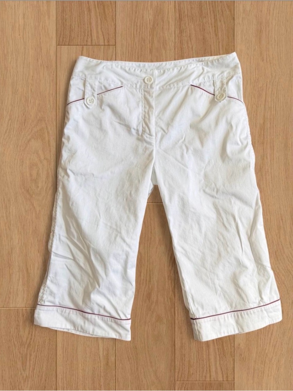 Cute white capri pants with dark red piping and belted pocket details